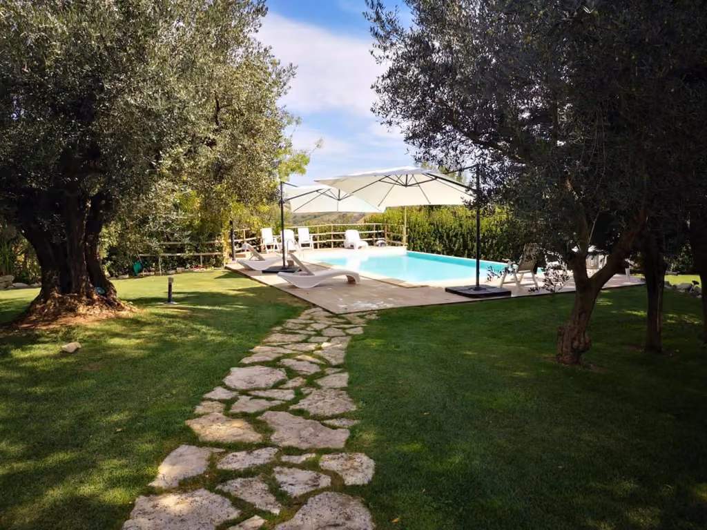 La piscina dell'agriturismo con i lettini intorno alla vasca