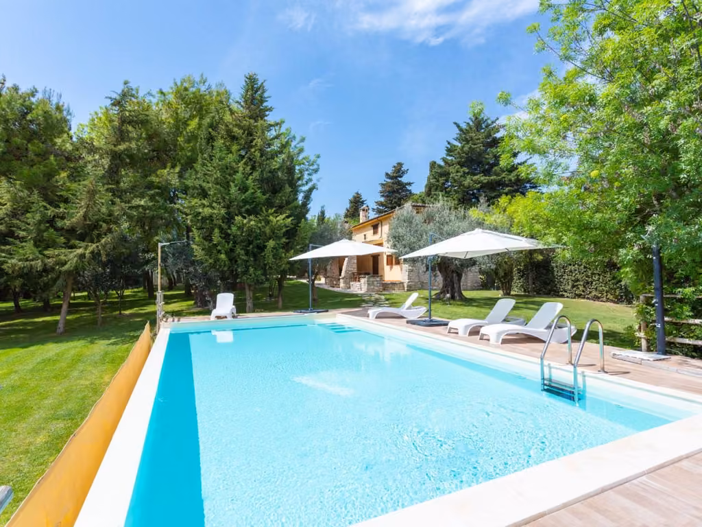 La piscina con il solarium e gli ombrelloni
