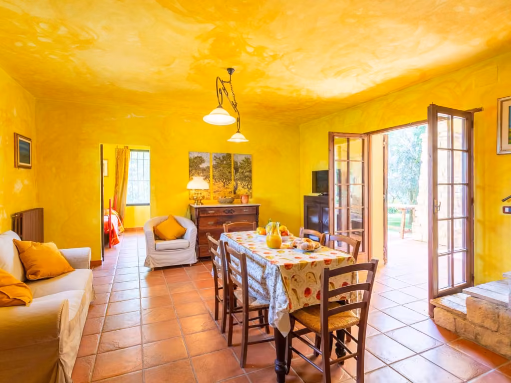 Soggiorno dell'appartamento dell'agriturismo, con tavolo, sedie e angolo cottura