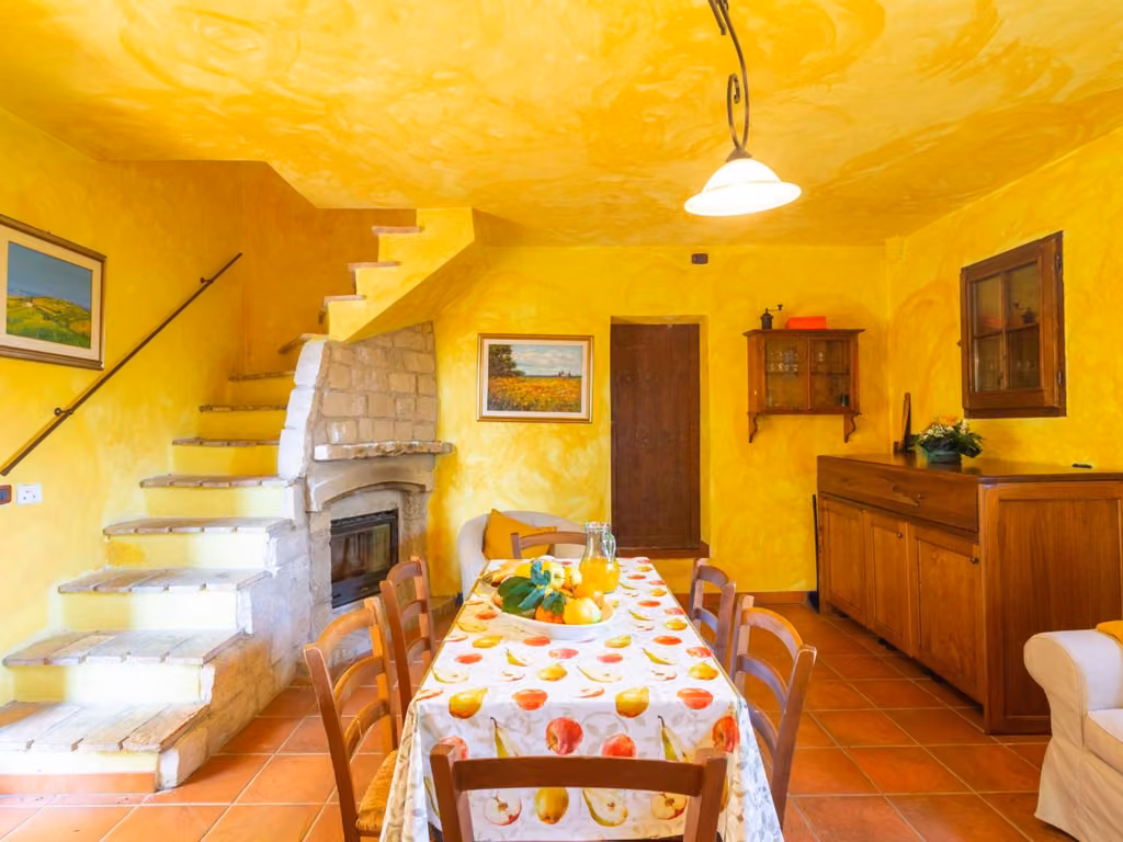 La sala da pranzo dell'agriturismo con il tavolo e il camino